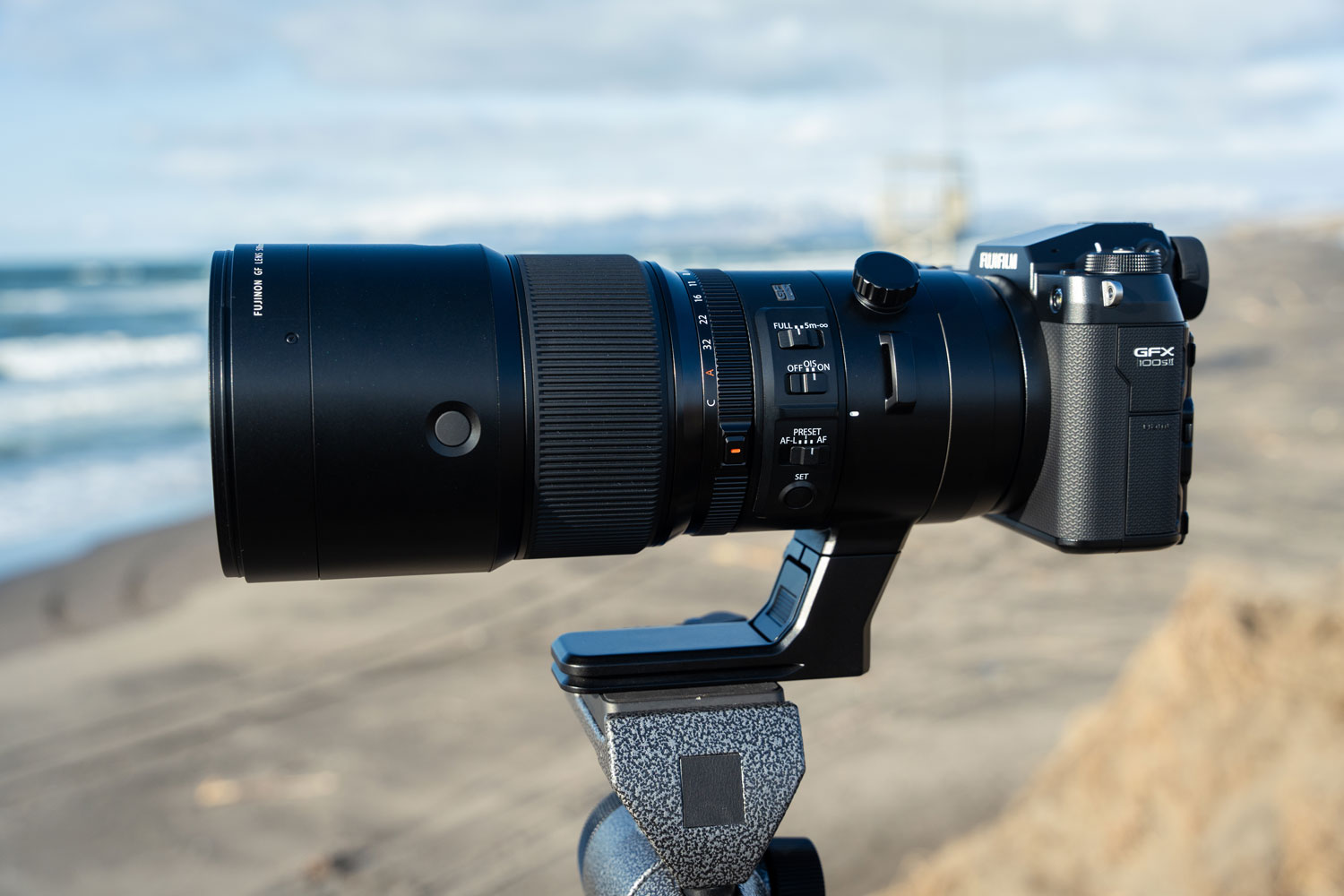Камера Fujifilm GFX100S II и объектив GF500mm f/5,6, закрепленные на штативе на пляже